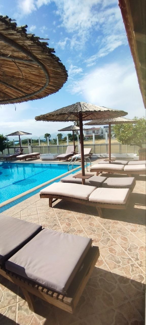 Poolside sunbeds beneath parasols